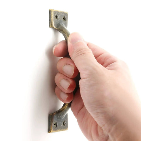 Hand holding 4 Pack 4 Inch Bronze Metal Cabinet Handles Rustic Drawer Pulls Vintage Curved Cupboard Handles For Kitchen Cabinets Furniture