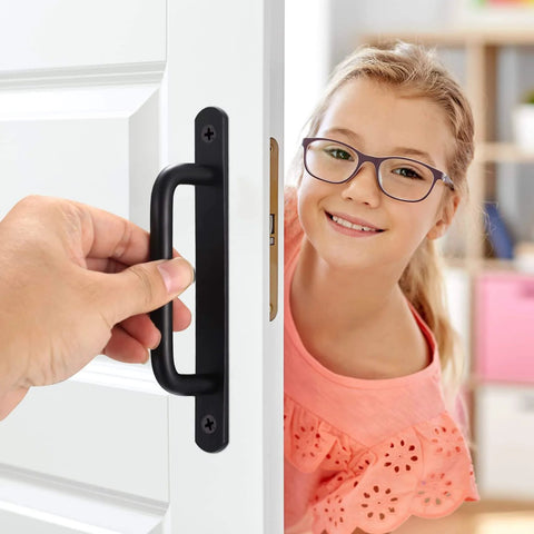 Person holding Two Pack Barn Door Handles Set Sliding Door Pulls Stainless Steel With Black Finish And Plates on a white door.
