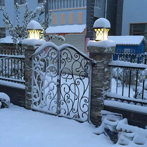 Outdoor Column Light With IP54 Waterproof Rating Glass Shaded Aluminum Post Lamp for villa gate in snow, lit at dusk.