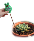Hand using Soil Moisture Tester Kit For Plants And Lawns, Indoor Outdoor Humidity Meter in green frog shape on potted succulent