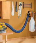 Hardcore 4 Inch Antistatic Dust Collection Hose With A Flexible Helix Ten Foot Layout connected to a dust extractor in a workshop.