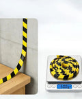 Hella Durable Foam Wall Corner Guards 197 Inches Yellow Black Stripes on edge of furniture and scale for measuring.