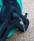 Close-up of the Pretty Slick Portable Garden Hose Reel With High Pressure Water Gun with water flowing, showing rugged design and connection.