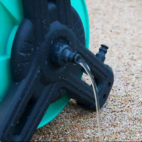 Close-up of the Pretty Slick Portable Garden Hose Reel With High Pressure Water Gun with water flowing, showing rugged design and connection.