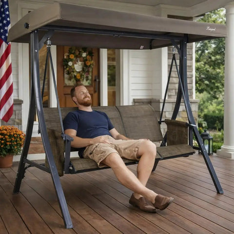 Man relaxing on Brenda 3 Seat Outdoor Porch Swing Glider with Adjustable Canopy on a porch