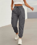 Woman wearing Women Lightweight Quick Dry Cargo Hiking Pants With High Waist Fit All Day Comfort Stretchy Parachute Style Baggy Travel Joggers.