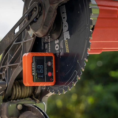 Klein Tools 935DAG digital angle gauge, orange, mounted on a circular saw blade.