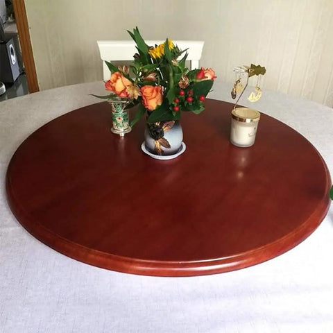 Top Shelf Natural Wood Lazy Susan Turntable Silent Swivel Serving Carousel With Heavy Hitter Load Capacity And Smooth Sailing Spin For Kitchen Island Setup And Party Spread on round wooden table with flowers.