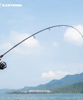 Person using Travel Ready 4 Piece Spinning And Casting Fishing Rods With Twin Tip at a scenic lake