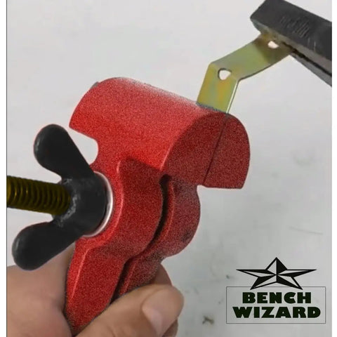 Close-up of a Tiny But Mighty 3 Inch Mini Handheld Vise with 1.25 Inch Jaws gripping a small metal part, adjustable wing nut visible.