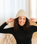 Woman wearing Satin Lined Beanie For Curly Hair Women Cozy Cable Knit Winter Hat With Frizz Free Moisture Retaining Satin Interior Curly