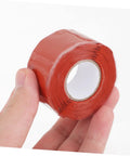 Hand holding red Leak Stop Tape For PVC PPR And Metal Pipes Flexible Self Adhesive Sealing Tape For Quick Waterproof Airtight Repairs