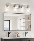 Four Light Brushed Nickel Bathroom Vanity Light With Clear Glass Shades above a bathroom mirror and sink.