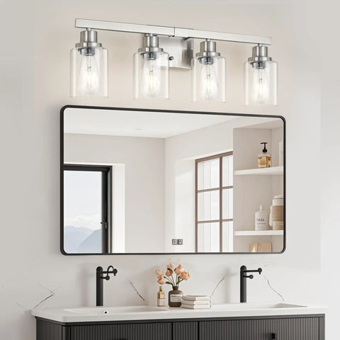 Four Light Brushed Nickel Bathroom Vanity Light With Clear Glass Shades above a bathroom mirror and sink.