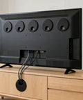 Premium Desktop Grommet Covers Slick Cable Organizers Hella Tough ABS Plastic Wire Routing Kit For Working From Home Office Setup No Mess Cord Management 5 Pack Black Two Point Five Inch Opening Sweet Fit Design, showing TV with cables organized through grommet.