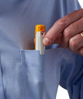 Fluke FIBERLERT-125 fiber optic tester in orange and white, held near a shirt pocket