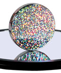 Chrome disk with colorful foils on a 9-inch mirror base, part of Euler's Disk Kinetic Toy With Interchangeable Foils For A Hypnotic Light And Sound Display That Doubles As Desk Decor For Home And Office Ideal For Adults And Kids 8 And Up.