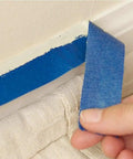 Blue Painters Tape 180 Yards Removable Masking Tape For Painting And DIY Projects With Sharp Edges For Walls Wood Glass And Trim Great For Classrooms Three Rolls 0.7 Inch By 60 Yards Each being peeled from a wall