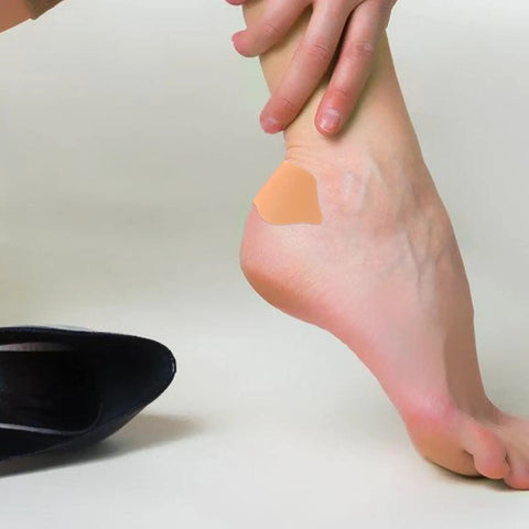 Self Adhesive Heel Protectors Soft Foam Cushion Pads For Shoes Wear Resistant Anti Blister Heel Grips on a foot against a black heel.