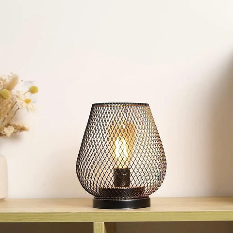 Metal Cage LED Lantern Battery Powered Cordless Accent Light on wooden shelf with warm white glow indoors