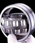 Heavy Duty Self Aligning Roller Bearing 22215 CAK W33 Single Pack showing inner spherical rollers and steel construction.