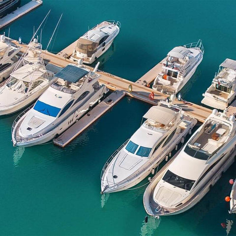 Luxury yachts docked in a marina, showcasing a pristine marine environment, ideal for using Dockside Ready Marine Grade Lubricant And Penetrating Oil For Boats And Gear, Biodegradable Food Grade Rust Prevention Spray, Anti Seize, Cleaner And Lubricant For Galleys, Fiberglass And Fishing Gear, 16 Oz.