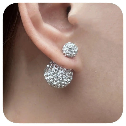 Rhinestone Double Ball Stud Earrings Set With Sparkling Crystal Orbs Clear Light Blue Royal Blue Pink And Multicolor Disco Ball Finishes Hypoallergenic Jewelry for Women Everyday Bling for Sensitive Ears 16mm by 8mm close-up on ear