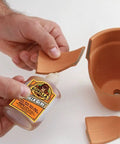 Heavy Duty Waterproof Polyurethane Glue In Rich Brown used to bond ceramic pot fragments, demonstrating effective repair capabilities.