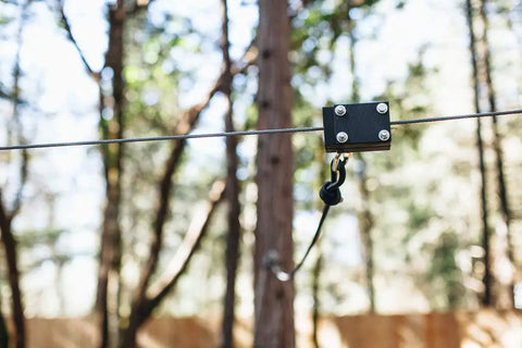 60Ft Zipline Brake System With Heavy Duty Bungee Cords And Plastic Brake Block installed on a zipline in a forest setting