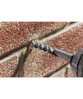 Close-up of a masonry drill bit, 3/4 in x 4 in x 6 in fast-spiral, drilling into brick.