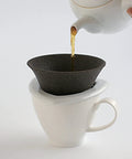 Japanese Ceramic Coffee Filter With Reusable Blue Dripper Stand And Eco Friendly Micropore Design For A Smooth Next Level Pour Over Brew That Truly Hits Different pouring coffee into a white mug.