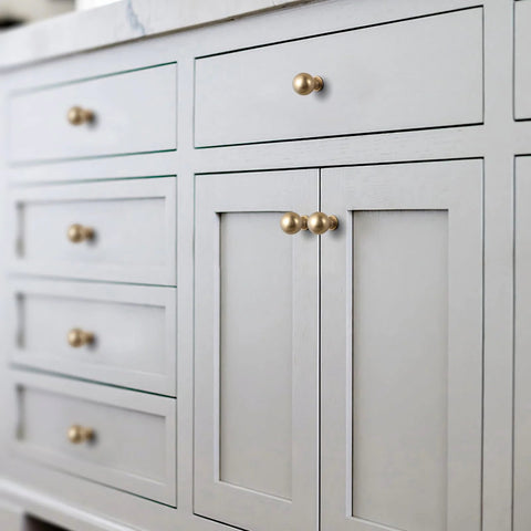 Close-up of furniture with Six Pack Zinc Alloy Drawer Knobs 0.94 Inch Diameter Champagne Bronze Cabinet Knobs in modern style installed.