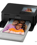 Selphy CP1500 Wireless Photo Printer in black printing a 4x6 photo, showing compact, portable design with easy setup and WiFi connectivity.