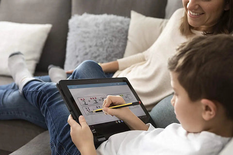 Child using No Plug Needed Jumbo Digital Stylus Pen With Eraser For Touchscreens on a tablet, seated on a sofa.