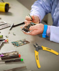 Technician using micro cutter flush cutter with angled jaws for electronics assembly.