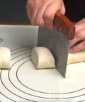 Using Heavy Duty Bench Scraper For Flat Top Griddle, Dough Cutter And Bread Pizza Scraper on dough, stainless steel chopper visible