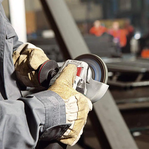 Worker using Beefy Torque 5 Inch Variable Speed Angle Grinder With Electronic Speed Control in a workshop setting, close-up view.
