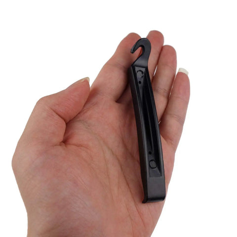 Hand holding bike tire lever from Eight Pack Bike Rim Tape And Three Tire Levers Kit For 26 Inch Or 700C Rims