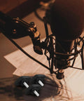 Rock Solid Microphone Stand Thumb Screws Decked Out With Tee Wing Knobs on a studio desk with a microphone.