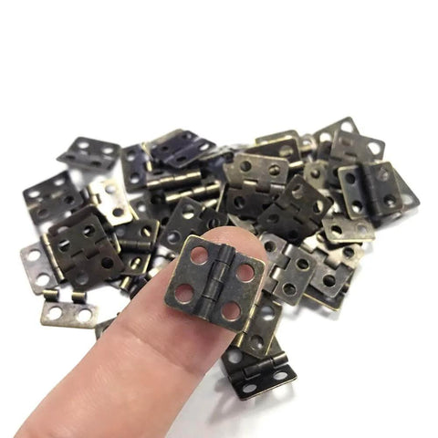 Close-up of vintage style mini copper hinges set with 50 pieces and 200 nails for wooden boxes, jewelry chests, and cabinets.