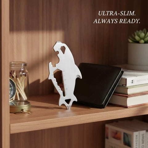 Wallet Sized Stainless Steel Multi Tool Card With Utility Slot And Ruler displayed on a shelf with a wallet and books.