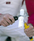 Using the Dual Blade Folding Painter Tool Five In One Stainless Steel Multi Tool With Flexible Putty Knife to clean a paint roller
