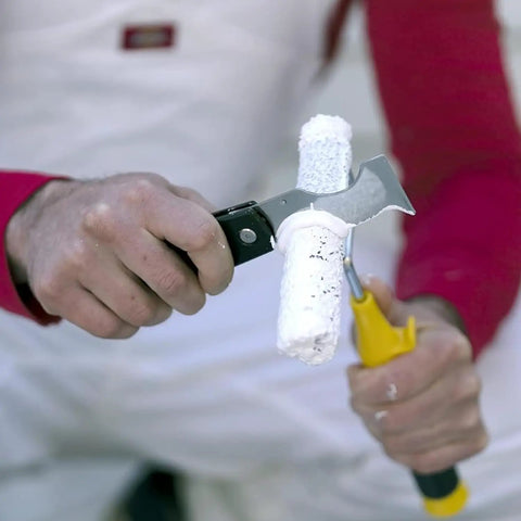 Using the Dual Blade Folding Painter Tool Five In One Stainless Steel Multi Tool With Flexible Putty Knife to clean a paint roller