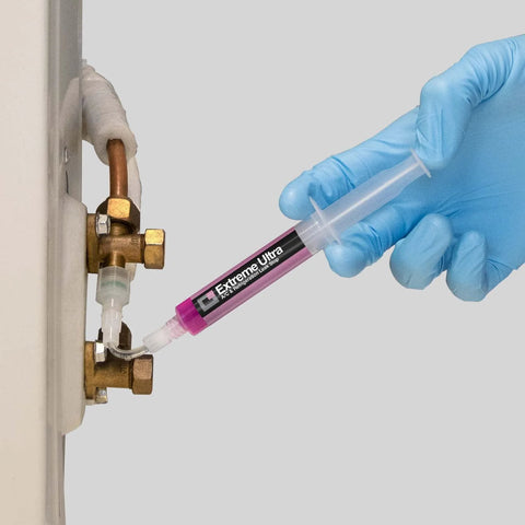 ERRECOM Extreme Ultra A/C leak-stop cartridge inserted into a copper HVAC line with 1/4 and 5/16 adapters