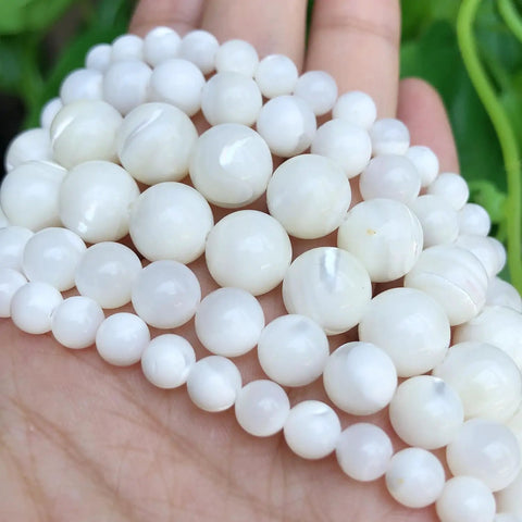 Legit Premium Natural White Pearl Shell Beads For Diy Jewelry Making With Awesome Iridescent Glow And Smooth Round Edges on a hand.