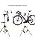 Two Leg Bike Repair Stand For Home Mechanics, Easy Setup Bicycle Maintenance Rack holding a bicycle, black and bronze finish