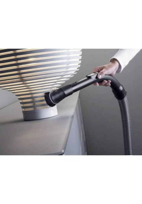 Using Attachable Dusting Brush For Vacuum Cleaners With Flexible Swivel Joint Pro Grade Furniture Care on a lamp base.