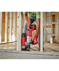 Top Shelf Brushless M18 Rotary Hammer With D Handle And Sds Plus Chuck in use drilling a hole in wooden framework.