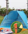 8 Pack Must Have Safety Orange Tent Stakes 8.8 Inch Plastic Anchors holding blue tent on green grass