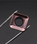 Close-up of Pro Grade Carbide Inserts for CNC Metal Turning Tools, seen held by tweezers, with a focus on cutting edge design.